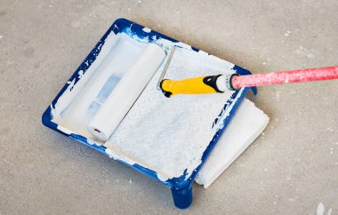 İçinde boya tepsi ile beyaz renk boya silindiri.