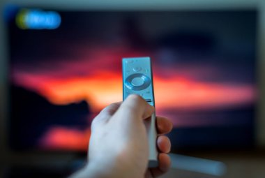 Erkek el tutarak TV uzaktan kumanda.