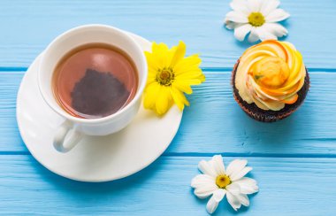 Fincan çay ve kek üzerine ahşap mavi arka plan ile natürmort