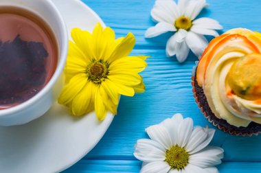 Fincan çay ve kek üzerine ahşap mavi arka plan ile natürmort