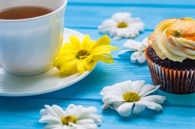 Fincan çay ve kek üzerine ahşap mavi arka plan ile natürmort