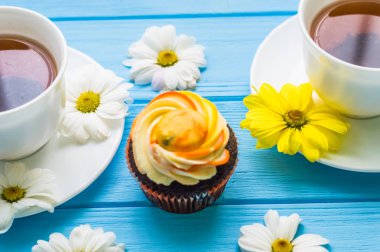 Fincan çay ve kek üzerine ahşap mavi arka plan ile natürmort