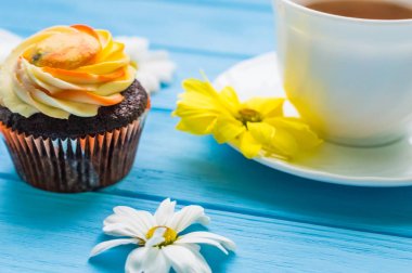 Fincan çay ve kek üzerine ahşap mavi arka plan ile natürmort