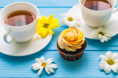 Fincan çay ve kek üzerine ahşap mavi arka plan ile natürmort