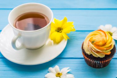 Fincan çay ve kek üzerine ahşap mavi arka plan ile natürmort