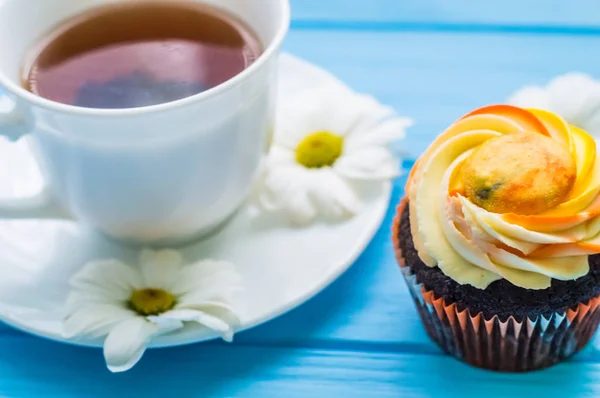 Stillleben mit Tee und Kuchen auf dem hölzernen blauen Hintergrund — Stockfoto