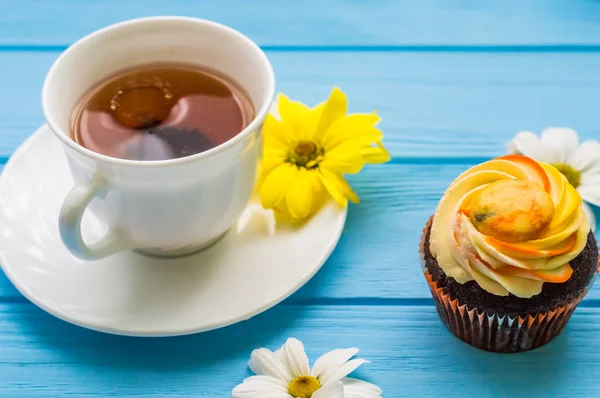 Stillleben mit Tee und Kuchen auf dem hölzernen blauen Hintergrund — Stockfoto