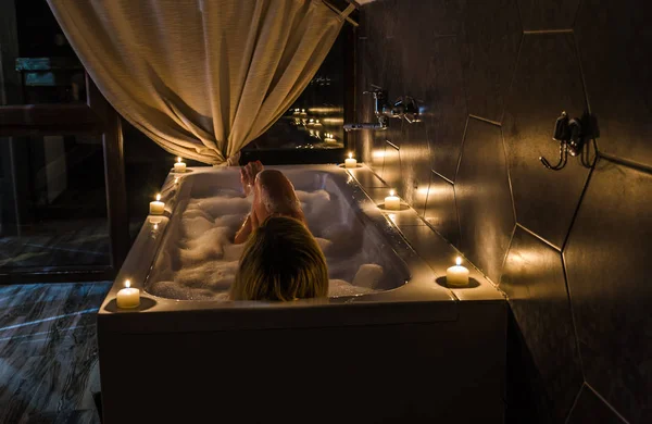Молодая девушка в ванной со свечами и вином — стоковое фото