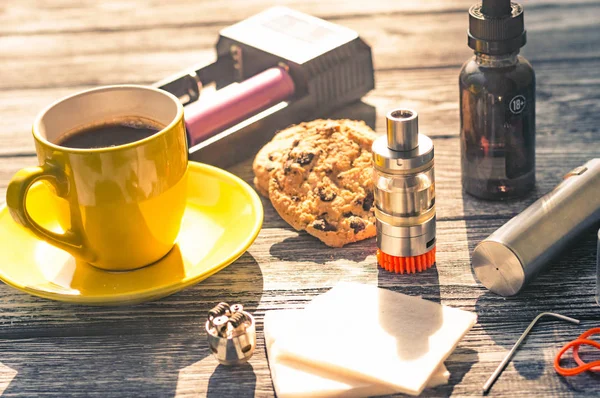 Bodegón con cigarrillo electrónico con botella y café — Foto de Stock