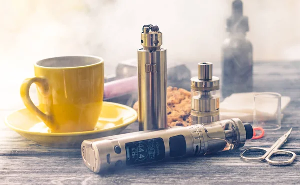 Bodegón con cigarrillo electrónico con botella y café — Foto de Stock