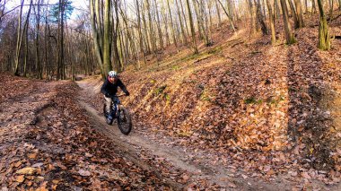 Sonbahar parkında bisiklet süren amatör bir binici.