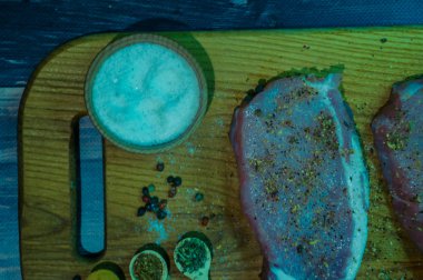 Ahşap arka planda çiğ yiyecek ve baharatlarla dolu sakin bir hayat