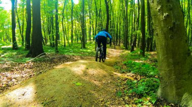 Bahar parkında bisiklet süren amatör bir binici.