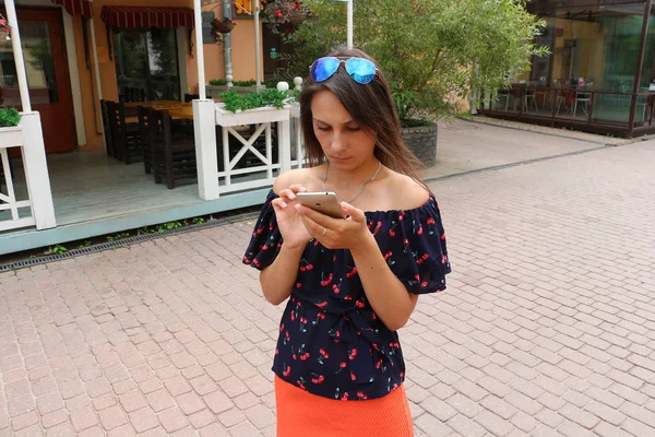 Mädchen mit Smartphone auf der leeren Straße — Stockfoto