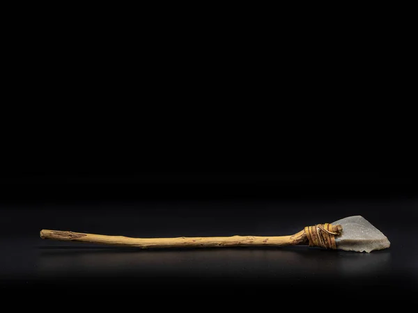 木製のハンドルと黒の背景に隔離された革のストラップを持つ主要な石のツールのレプリカ 原始的な石槍または斧 先史時代の人々の武器 — ストック写真