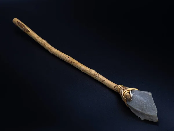 木製のハンドルと黒の背景に隔離された革のストラップを持つ主要な石のツールのレプリカ 原始的な石槍または斧 先史時代の人々の武器 選択されたフォーカス — ストック写真