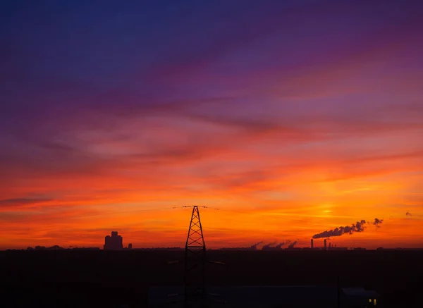 Colorful cloudy epic sky on sunset over the panoramic  silhouette of the Moscow city skyline and top of the transmission tower on foreground