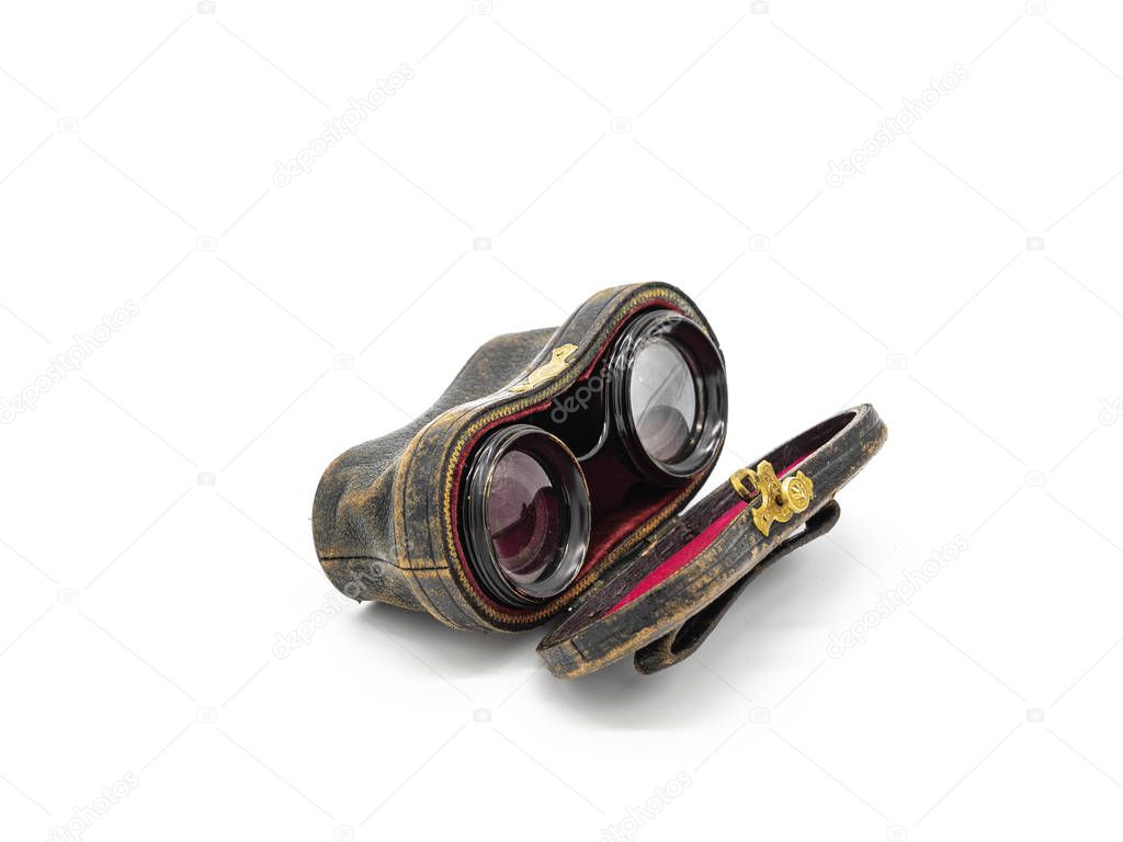 Antique opera glasses inside black leather case isolated on white background. Black small vintage binocular in purple velvet lined cover with figured metal lock.
