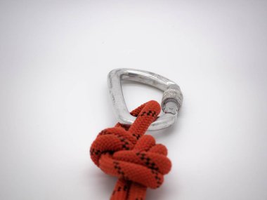 Karabinalı sekiz düğüm. Kilitli gümüş karabina ve beyaz üzerinde kırmızı ip.