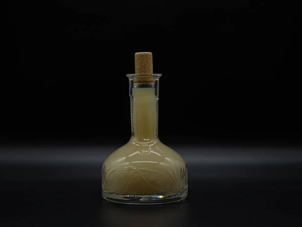 Koyu arkaplanda turbikli ev yapımı votka olan klasik sürahi. Alkolik içki, şeffaf şarap şişesinde hrenovuha.