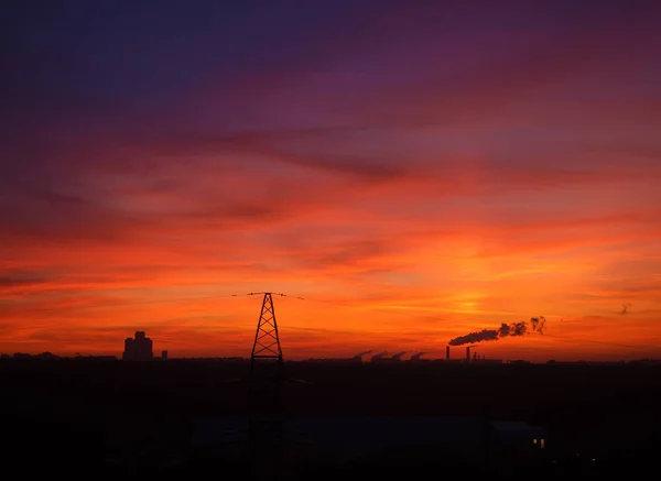 Colorful cloudy epic sky on sunset over the panoramic  silhouette of the Moscow city skyline with transmission tower on foreground