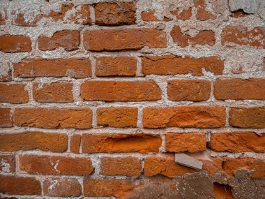 Eski kırmızı grunge tuğla duvar doku gibi görünüyor. Farklı şekilli tuğlalarla tuğla işçiliğinin yakın görüntüsü.
