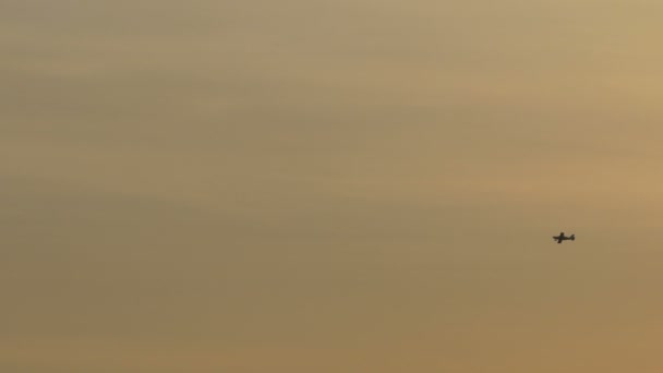 Klein vliegtuig vliegen in de zonsondergang — Stockvideo