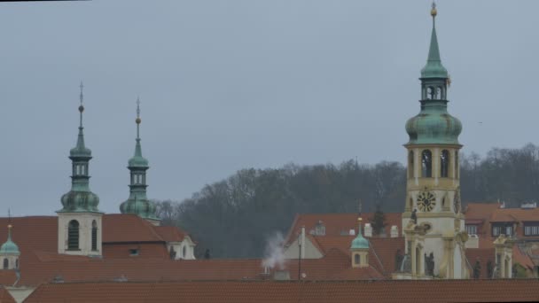 Věže a střechy v šedé autmun den v Praze.