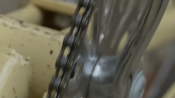 Chaîne à rouleaux de vélo huilée traversant les dents de l'engrenage .