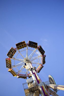 Gençler bir fuar alanı ve mavi gökyüzü arka planda bir binen