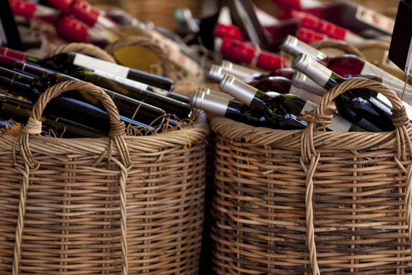 Red wine bottles in baskets — Stock Photo, Image