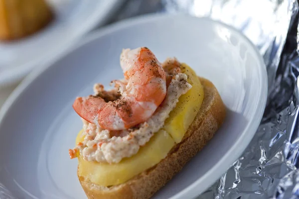 Garnalen, zeevruchten mousse en plakje aardappel op een toast — Stockfoto