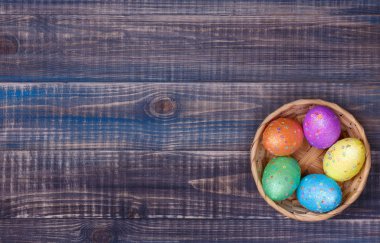Beş renkli Paskalya yumurta ile bir hasır sepet