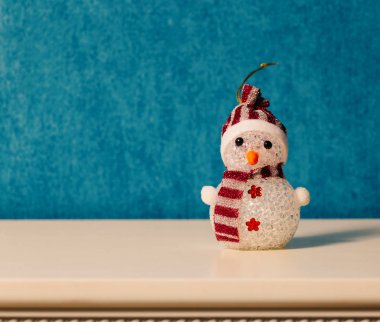 Mavi bir arka plan üzerinde oyuncak kardan adam.