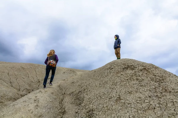 Mother and son visiting muddy volcano. Family climbing dry arid Stock Image