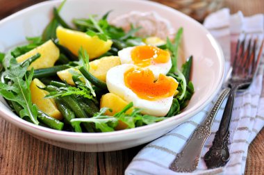 Sebze salatası yeşil fasulye, patates, roka, yumurta ve zeytinyağı ile. Vintage tarzı.