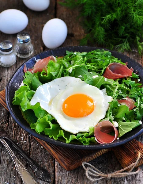 Marul, roka, parmesan ve jamon sahanda yumurta. Rustik gıda. — Stok fotoğraf