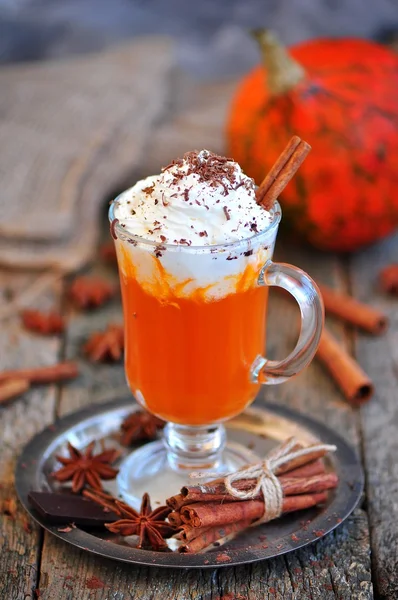 Smoothie à la citrouille avec cannelle et crème fouettée sur un fond en bois . — Photo