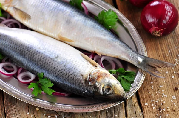 Salted herring with red onion and parsley on the old wooden background. — Stock Photo, Image
