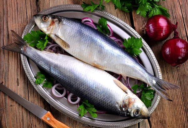 Salted herring with red onion and parsley on the old wooden background. — Stock Photo, Image