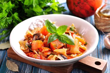 Kavrulmuş organik kabak, lahana, soğan, mantar, havuç, dereotu ve fesleğen.