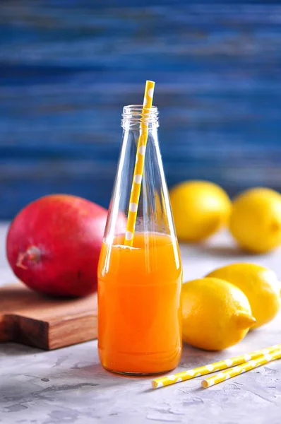 맛 있는 레몬 망고 주스 병에 빨 대와 병. — 스톡 사진