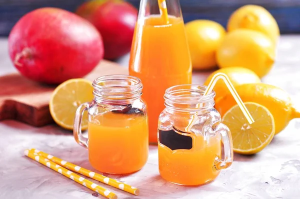 Вкусный лимонный сок манго в банке и бутылки с соломинкой . — стоковое фото
