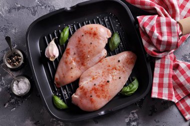 Füme kırmızı biber, deniz tuzu ve karabiberi dökme demir tavada ızgara ile çiğ tavuk göğsü.