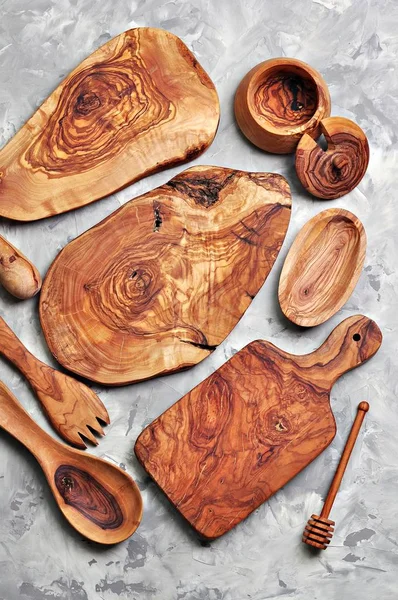 Various kitchen utensils made of olive wood - cutting boards, fork, spoon and container.
