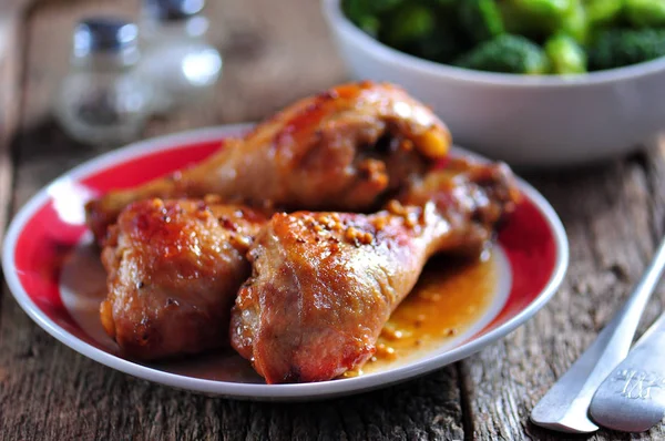 Gebakken kip drumsticks met sojasaus, honing en mosterd met gekookte broccoli graan. — Stockfoto