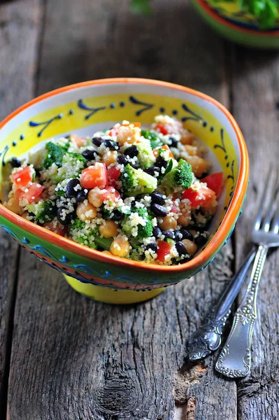 Ensalada saludable de garbanzos, cuscús, frijoles negros con tomate, brócoli, perejil, aceite de oliva y sal marina . — Foto de Stock
