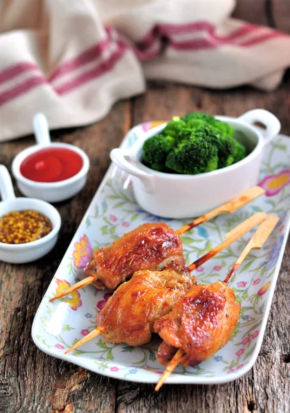 Delicioso kebab de pollo en pinchos de madera con brócoli hervido en el fondo de madera viejo . — Foto de Stock