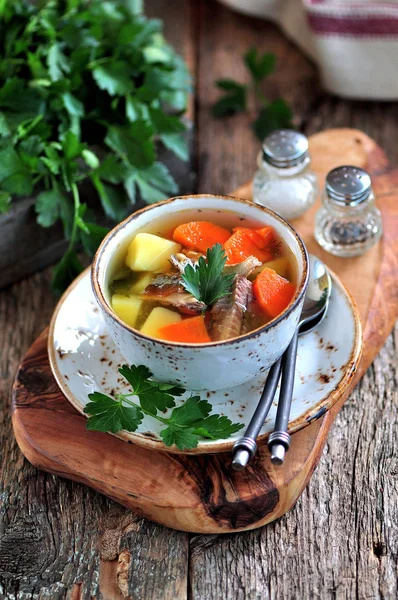 Рибний суп з картоплею, морквою та петрушкою на старому дерев'яному фоні . — стокове фото