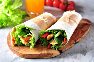 Izgara tavuk, kırmızı biber, salatalık ve marul ile tortilla rulo.